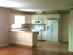 Die helle Kche mit groen Einbauelektrogerten.