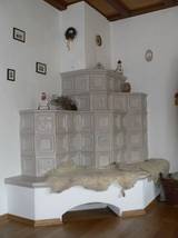 Im Wohnzimmer werden Kacheln aus der gleichen und einer verwandten Serie auf 3 Hhenebenen plus gemauerter Bank genutzt.  Die Formgebung gliedert die Flchen, die sonst viel zu klotzig wren, und gibt dem Ofen eine leichte, elegante Aura.