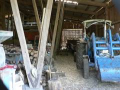 Innenansicht eines Teils der Maschinenhalle.  Rechts die Durchfahrt, links die betonierten Stellpltze, ganz links ein Teil des Heubodens.