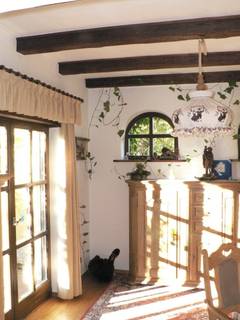 Das dem Wohnzimmer benachbarte Zimmer ist lichtdurchflutet, obwohl es hinter der Terasse und unter dem Balkon liegt. Über der Anrichte zwei halbrunde Fenster, die den Gemütlichkeitswert weiter erhöhen.